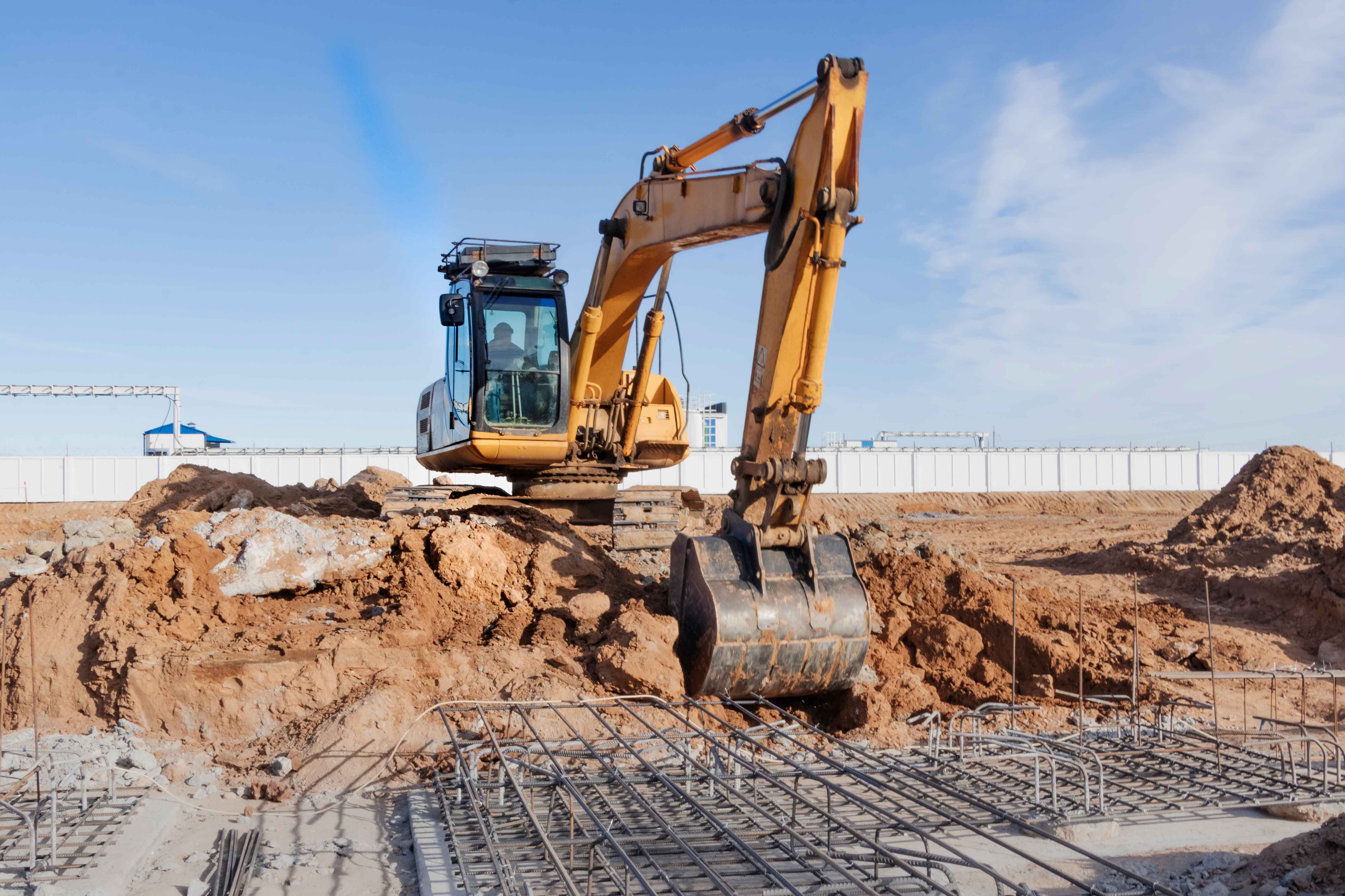 powerful-caterpillar-excavator-digs-ground-against-blue-sky-earthworks-with-heavy-equipment-construction-site_11zon.jpg